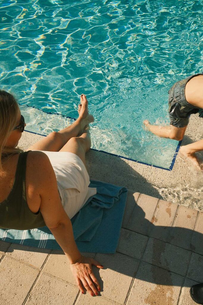 A family enjoying poolside relaxation, highlighting the resort-style amenities offered by Coast and Range Vacations