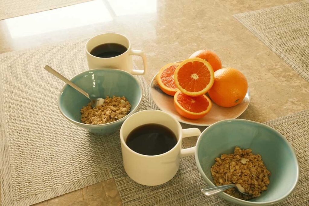 Fresh and simple breakfast with coffee, oatmeal, and grapefruit, reflecting the relaxed mornings staying with Coast and Range Vacations rentals.