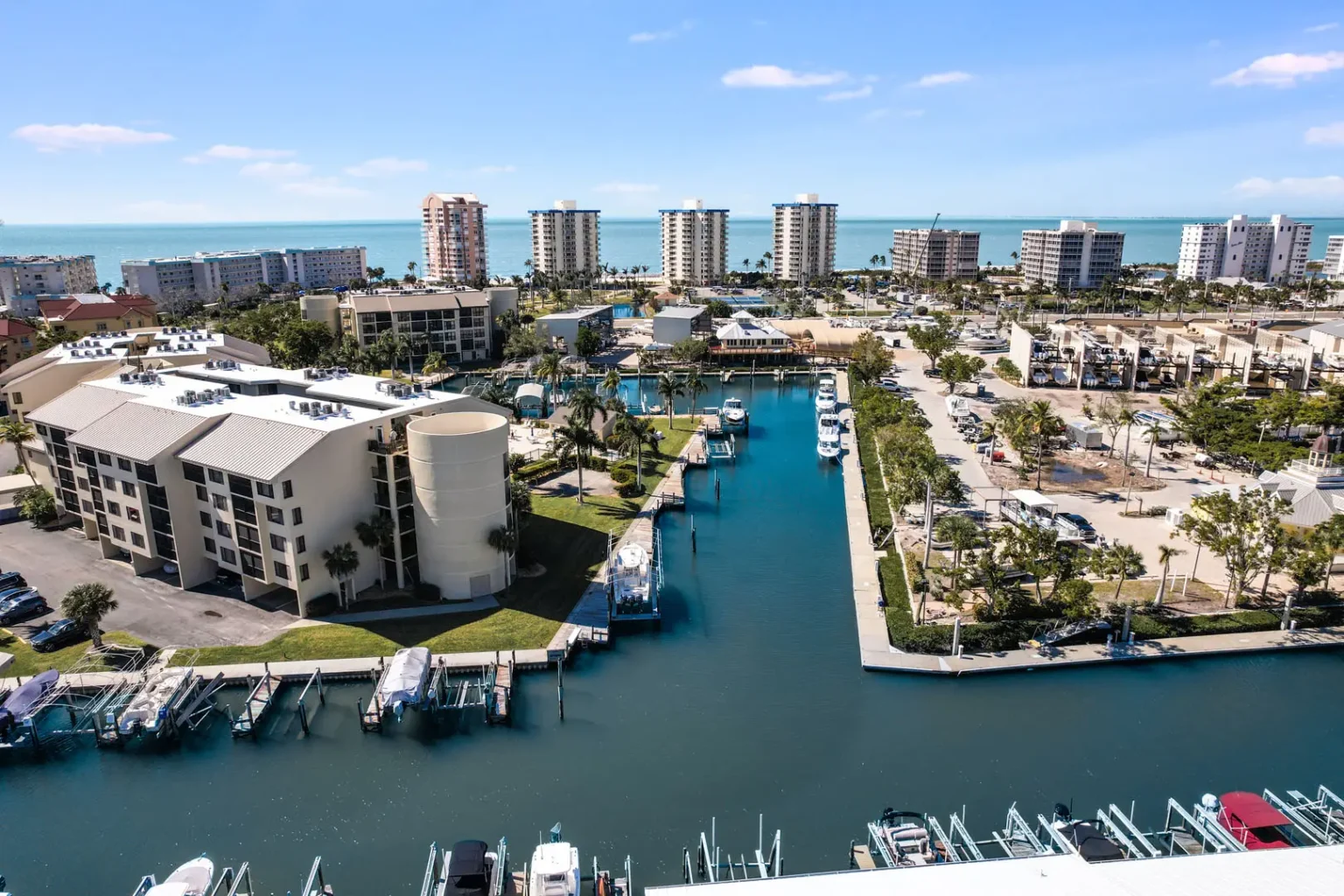 Waterfront property overlooking a marina with boats and wide coastal water views near the Gulf.